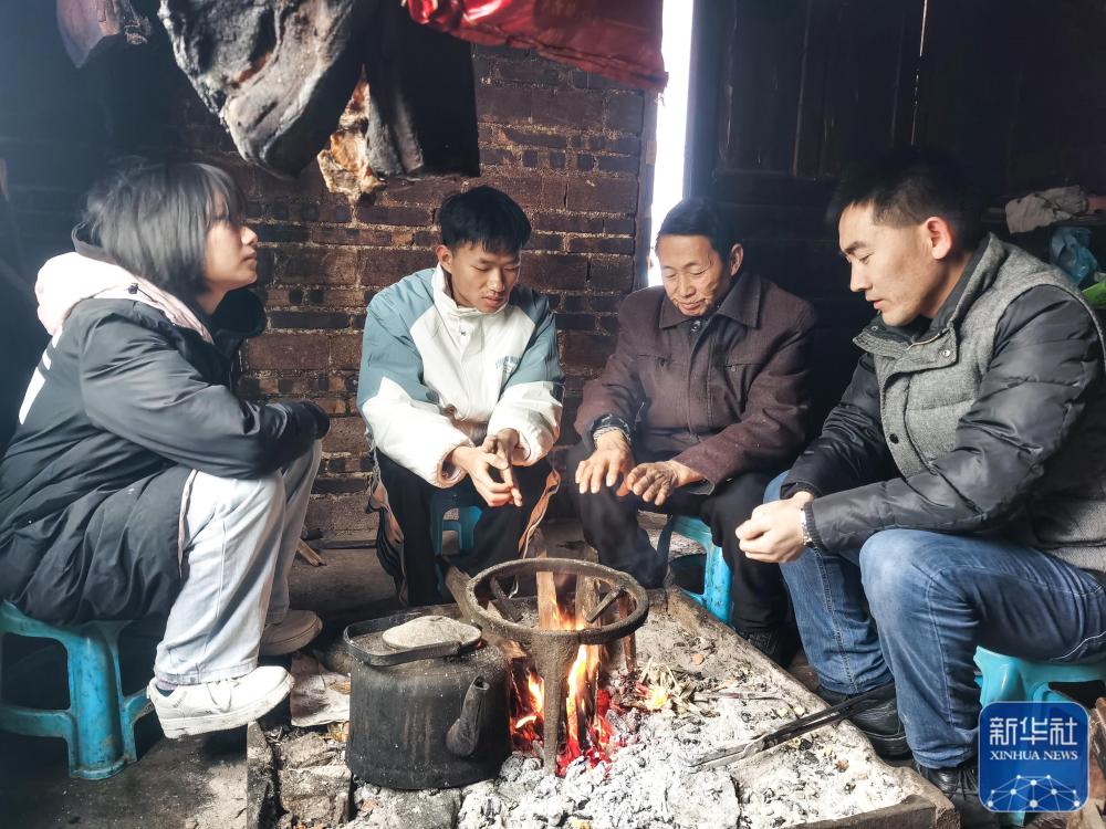 贵州省望谟县实验高中党总支副书记、副校长刘秀祥(右一)在学生家中家访(2022年2月1日摄)。新华社发